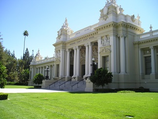 Riverside Historic Courthouse framed by manicured trees and green grass beneath a clear blue sky.